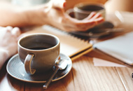 Two people having a conversation over coffee.