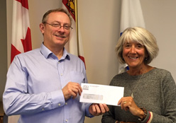 Staff member presenting cheque to The Auxiliary