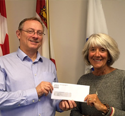 Staff member presenting cheque to The Auxiliary