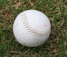 A white baseball on grass.