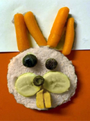 Bunny Sandwich 5 - Bunny face sandwich made from circle shaped bread, carrot ears, blueberry eyes and nose, banana slices for cheeks, rectangular cut cheese for teeth.
