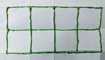 An eight box grid, created on a piece of white paper with green puff paint.
