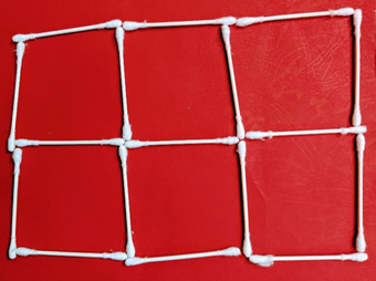 A six box grid, created on a piece of red card stock with white cotton swabs.