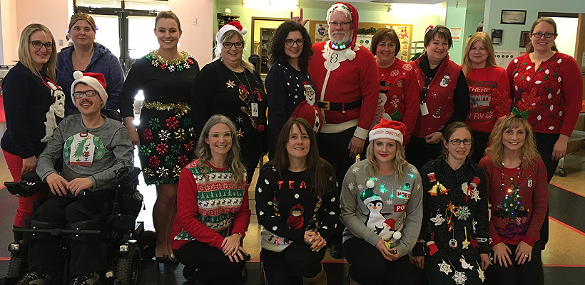 Staff and student in holiday sweaters
