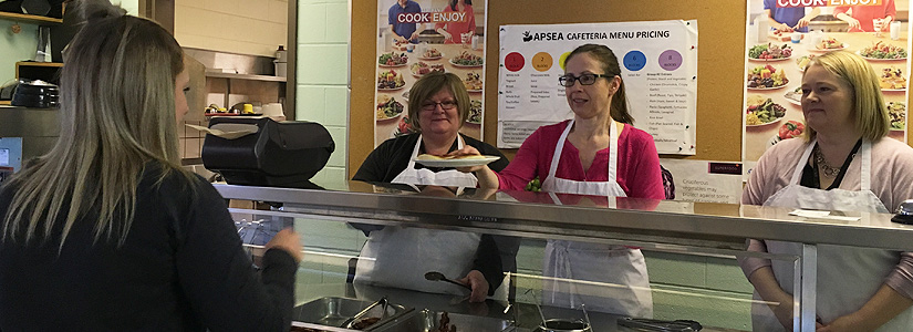 Leadership serving pancakes to a staff member