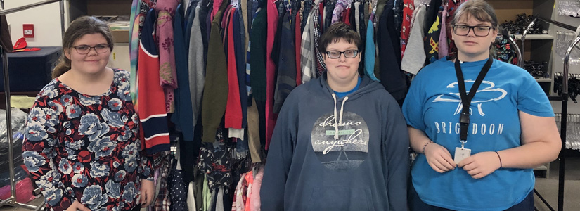 Students standing in front of clothing racks