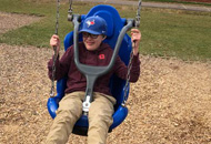 Child in swing with blue hat